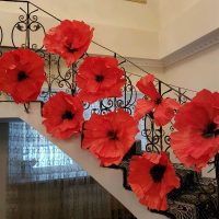 červené papírové květiny na fasádě haly fotografie