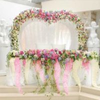 Pengaturan bunga dalam reka bentuk meja pengantin lelaki dan perempuan