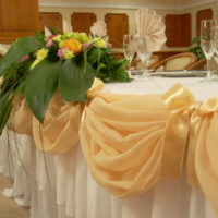 Smėlio spalvos tiulis ir slėnio lelijos vestuvių stalo dizaine