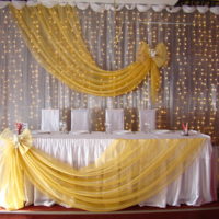 Vestuvių stalo gale esanti LED girlianda