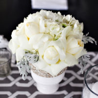 باقة احتفالية من الزهور البيضاء على طاولة العروسين