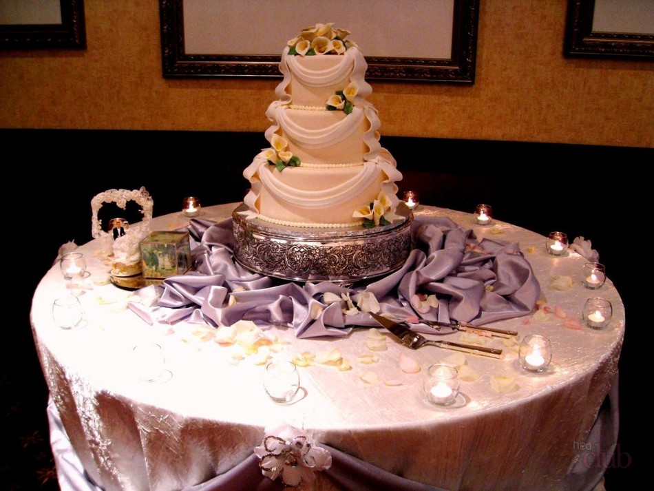 Vjenčana torta na stolu okružen svijećama