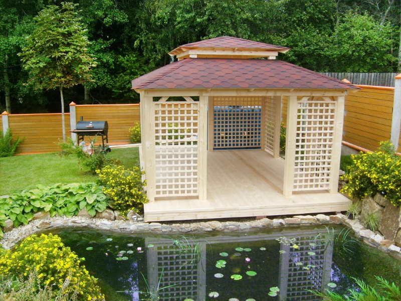 Fából készült kerti pavilon a kerti tó partján