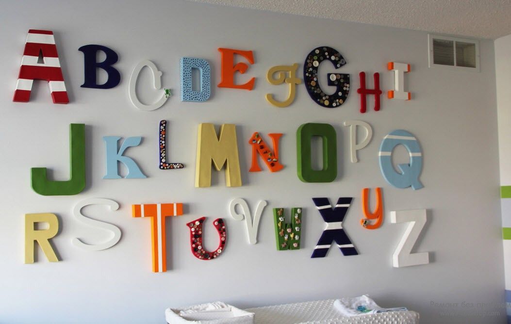 Spalvotos putplasčio raidės ant gyvenamojo kambario sienos