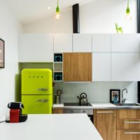Gaiši zaļš ledusskapis un kokam līdzīgas fasādes virtuvē