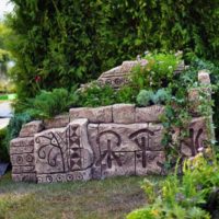 Puķu dobe ar hieroglifiem dārza noformējumā