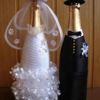 Рокля на булката и младоженеца върху бутилки с шампанско