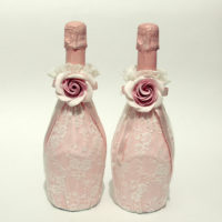 Големи рози върху сватбени бутилки с шампанско