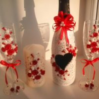 Червени и бели цветя в декора на бутилки с шампанско