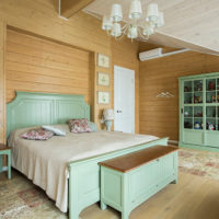 Mintkleurig meubilair in de slaapkamer van een houten huis