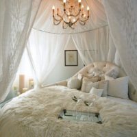 Světle bílá mikina přes postel manželů