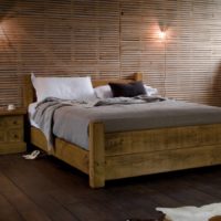 Dřevěná postel na prkenné podlaze