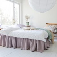 Witte slaapkamer met lavendel sprei