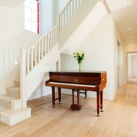 Dewan putih dengan piano di sebuah rumah negara