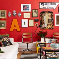 Dopis a obrazy na červené zdi obývacího pokoje