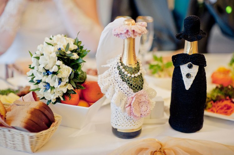 Vytváření šampaňského vlastníma rukama v šatech nevěsty a ženicha