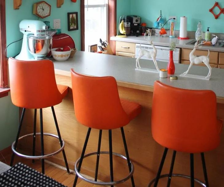 Oranžinės kėdės prie baro prekystalio virtuvėje