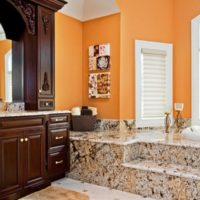 Oranžinės sienos ir marmurinės grindys vonios kambario dizaine