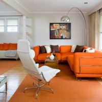 Interiér obývacího pokoje s oranžovou pohovkou u okna