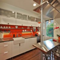 Oranžinė prijuostė virtuvės dizaine