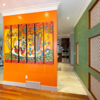Oranje scheidingswand met schilderijen in een woongebouw