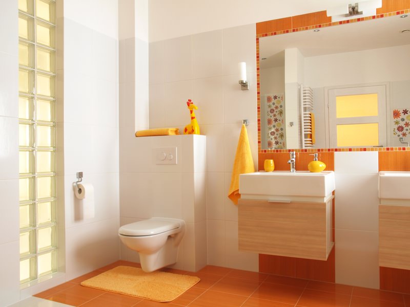 Oranžinis vonios kambario interjeras jaunos šeimos bute