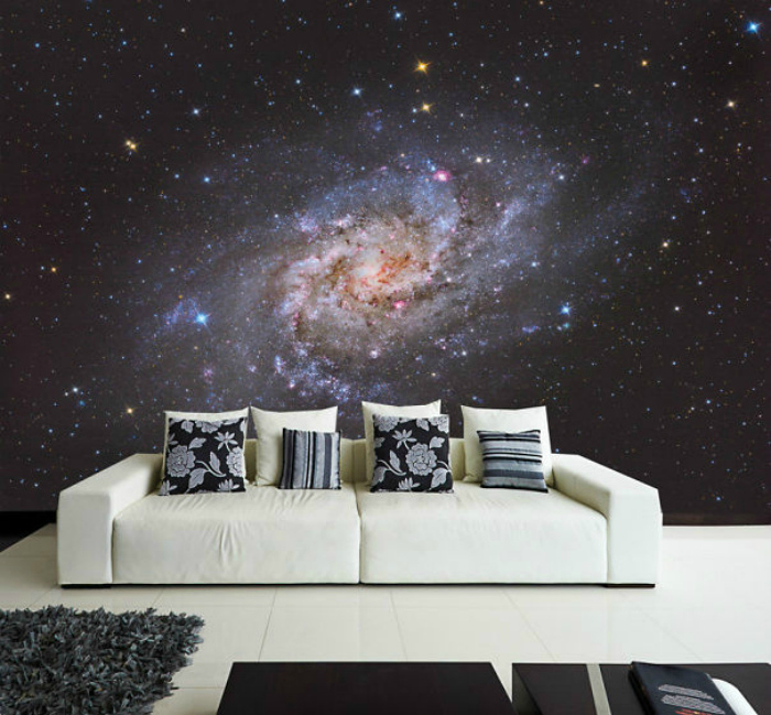 Balta sofa kosminių tapetų fone