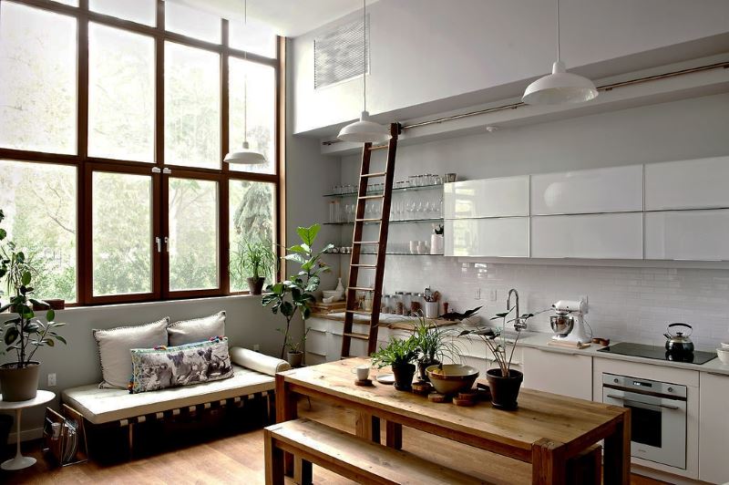Virtuvē-viesistabā ir lieli logi ar augstiem griestiem
