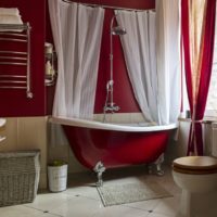Witte gordijnen in een rode badkuip