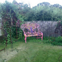Ярко боядисана пейка в частна градина