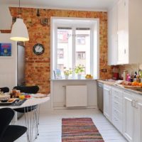 Brick accent in the interior of the white kitchen