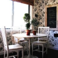 Бяла маса за хранене с живи растения в кухнята на градски апартамент