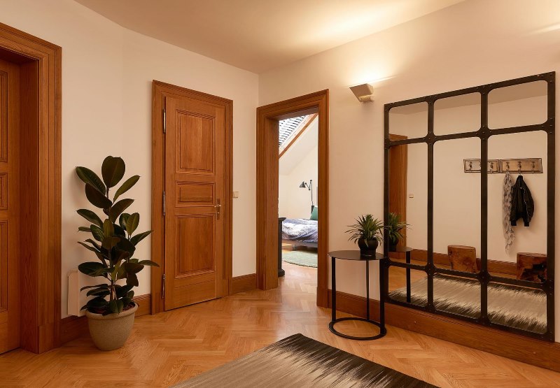 Entreehal van een woonhuis met bruine vloer en houten deuren