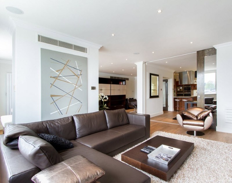 Interior ruang tamu minimalis yang cerah dengan sofa coklat