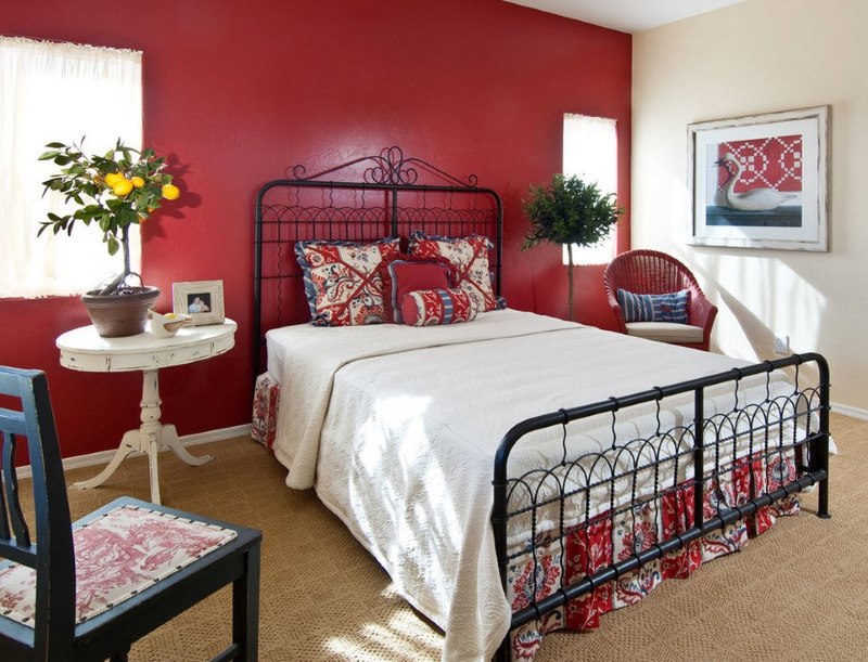 Комбинацията от бяло спално бельо с червена стена в спалнята