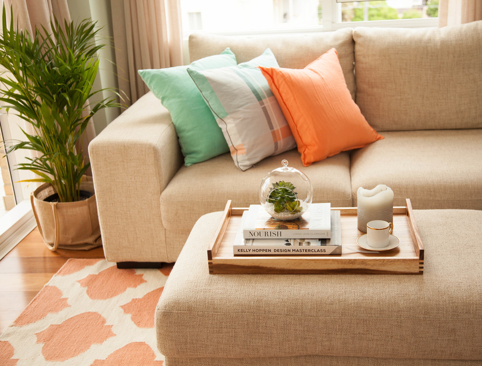 Bantal jingga di atas sofa dengan kain pelekat yang berwarna-warni