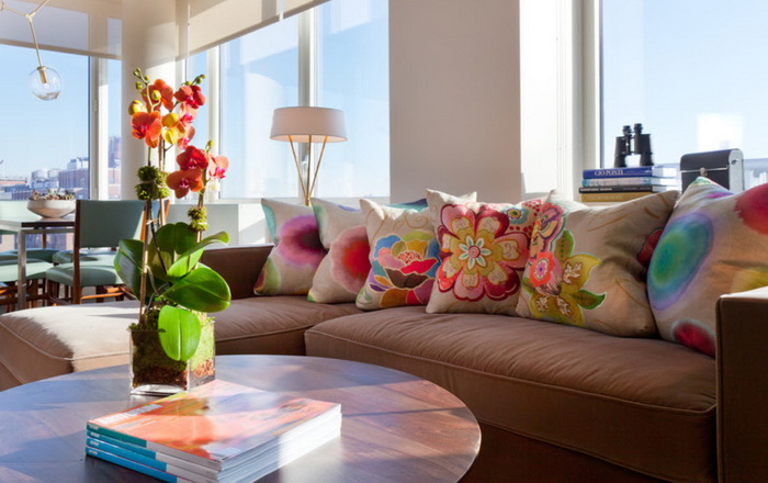 Възглавници с цветя на кафяв диван