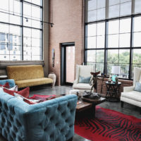 Zils dīvāns viesistabā ar panorāmas logiem