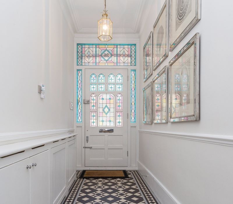 Pintu putih dengan tingkap kaca berwarna di koridor sempit