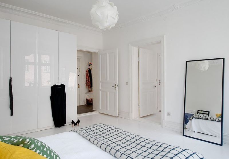 Skandinaviško stiliaus miegamojo dizainas su baltomis durimis