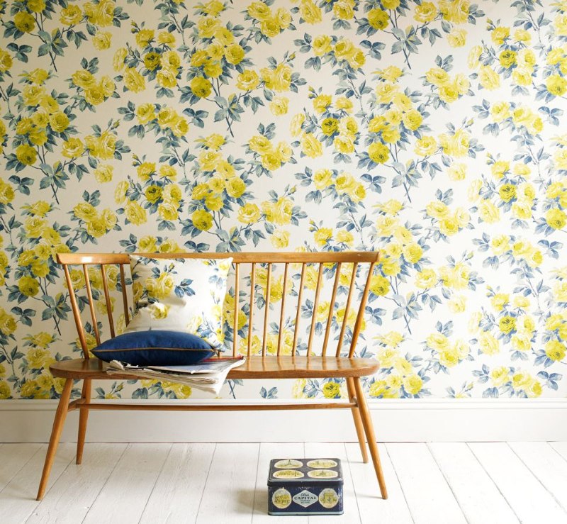 Wallpaper dengan bunga kuning di dinding ruang tamu sebuah rumah negara