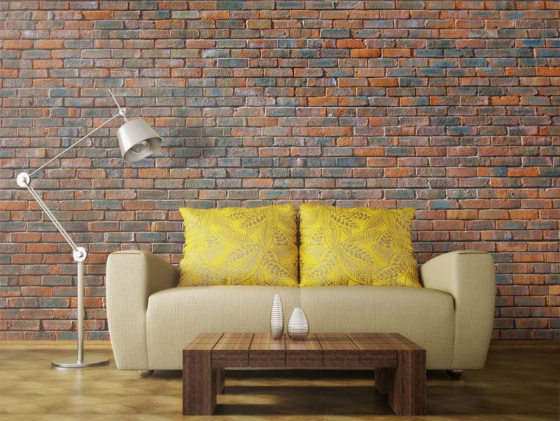 Cream upholstered sofa in front of a brick wall