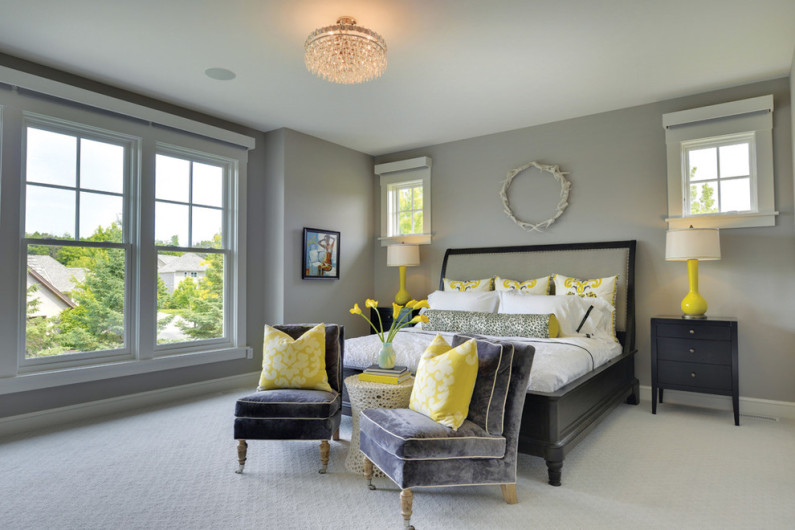 Žluté dekorativní polštáře v interiéru šedé ložnice
