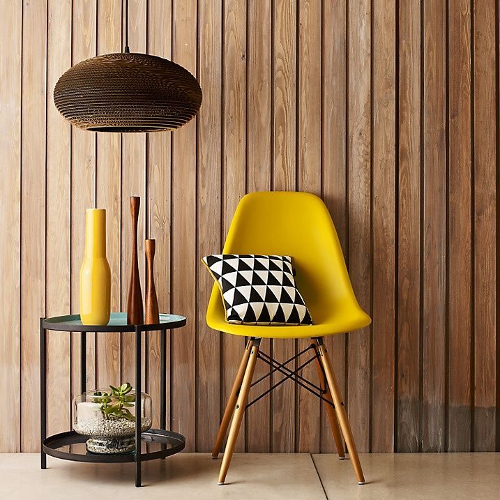 Gele stoel en houten wandbekleding