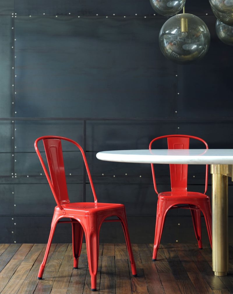 Twee rode stoelen tegen een zwarte muur
