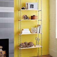 Rafturi pe lanțuri de un perete galben