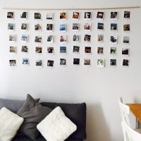 Balta siena ar fotogrāfijām uz koka dēļa