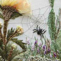 Broderie pe țesătură un păianjen printre flori