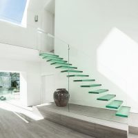 Дизайн на модерна зала със стъклено стълбище