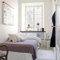 Pătură de culoare gri pe un pat alb